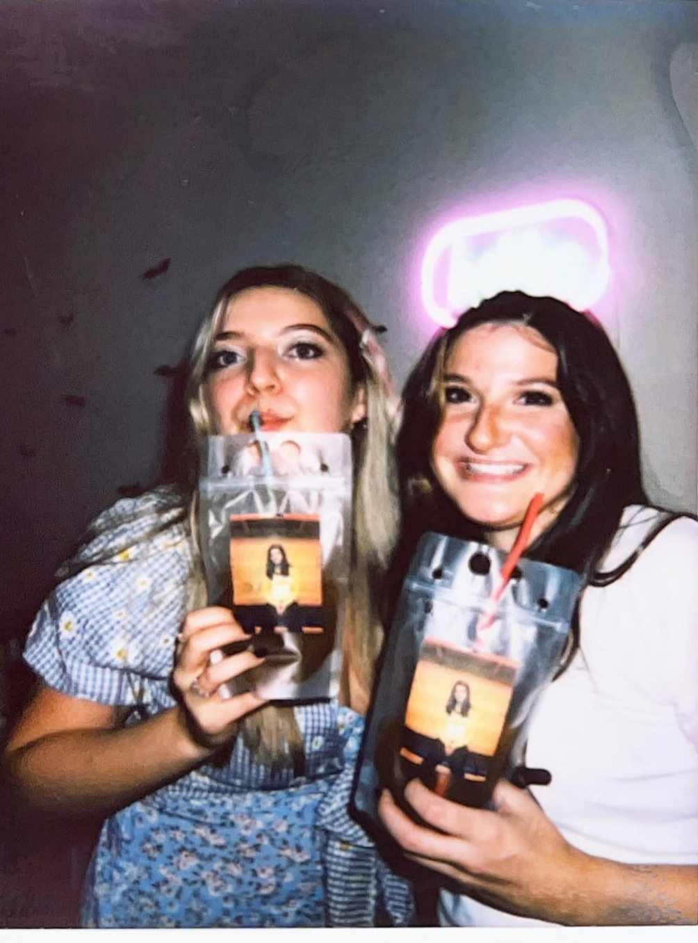 Two friends holding Whatcha pouches